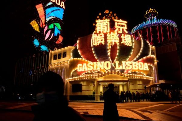 People wearing masks walk in front of Casino Lisboa, before its temporary closing following the coronavirus outbreak, in Macau, China, 4 February 2020 (Photo: Reuters/Tyrone Siu).